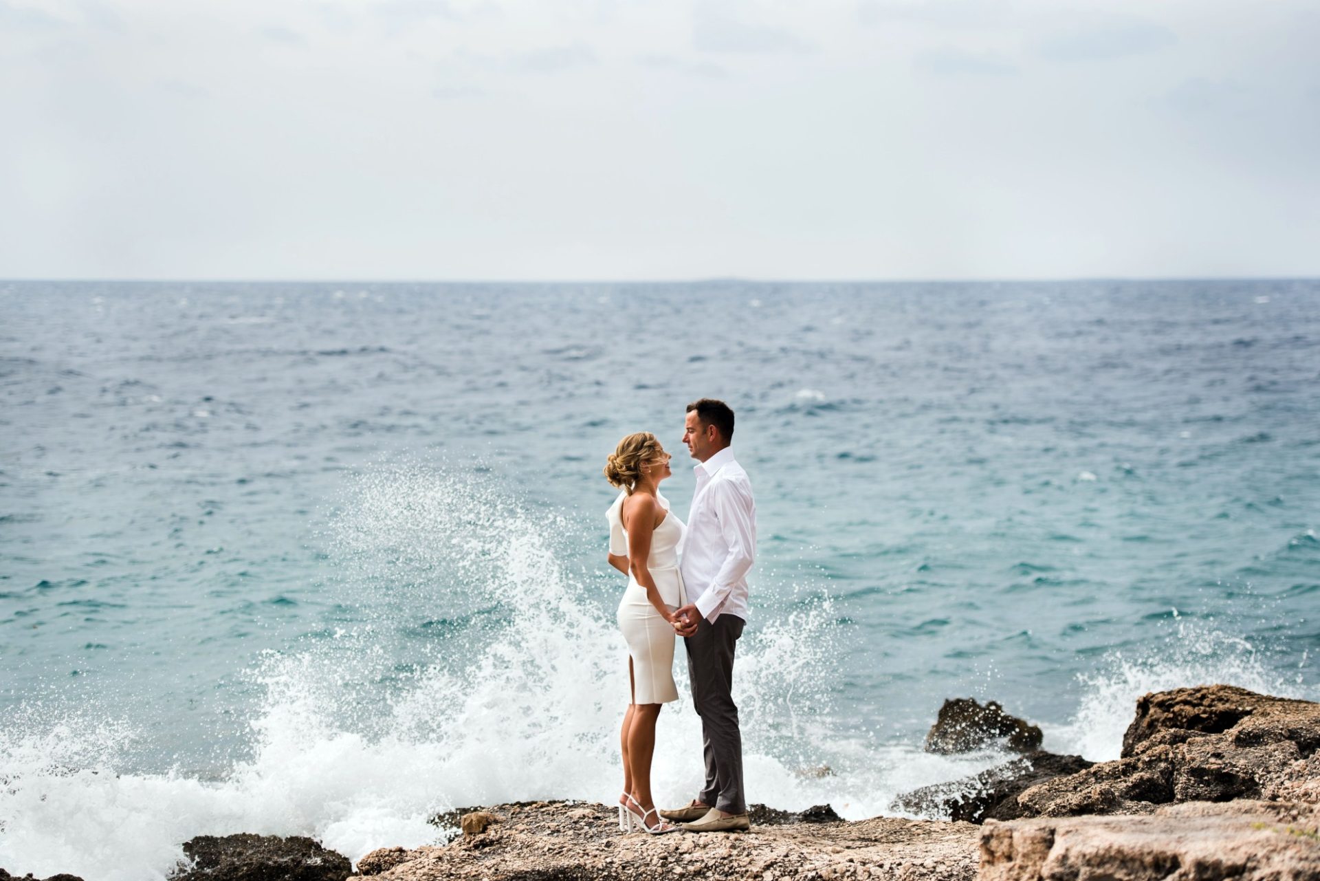 Married couple at the rocky coast.