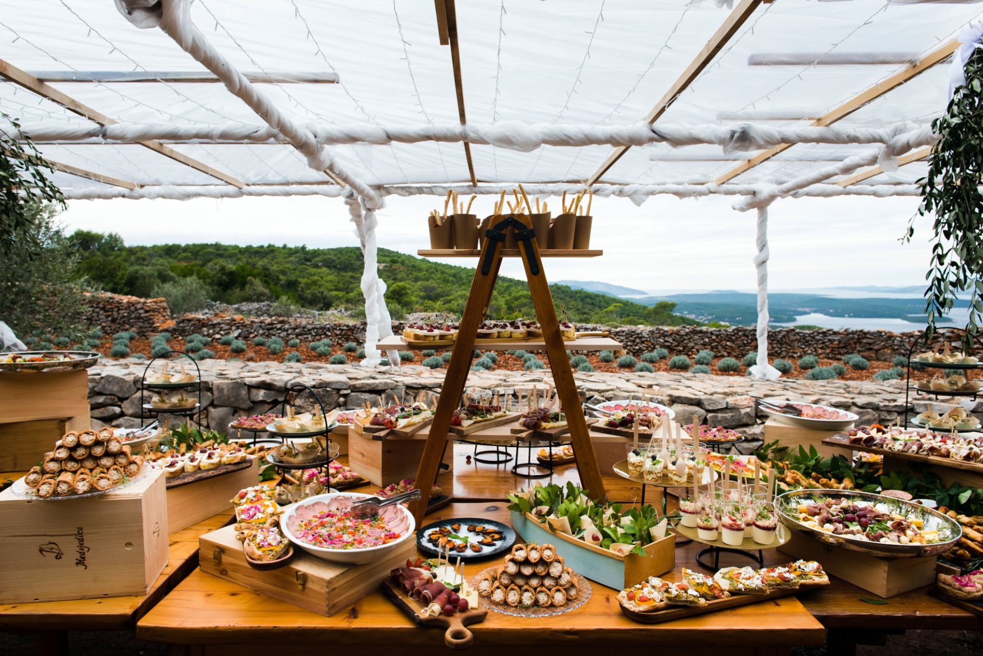 Table filled with sweets in front of the coast and mountains