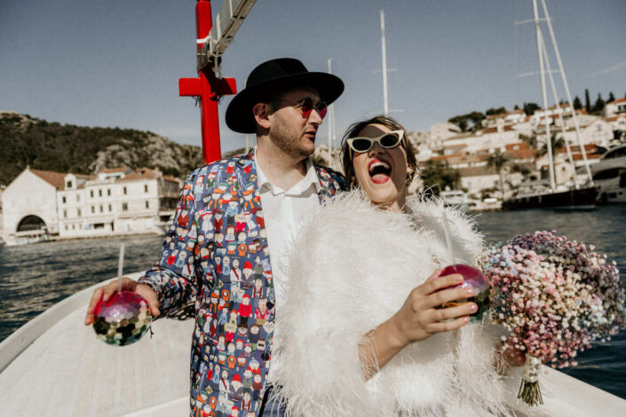 Beautiful couple on their wedding day happy and full of joy on the boat in Dalmatian village.